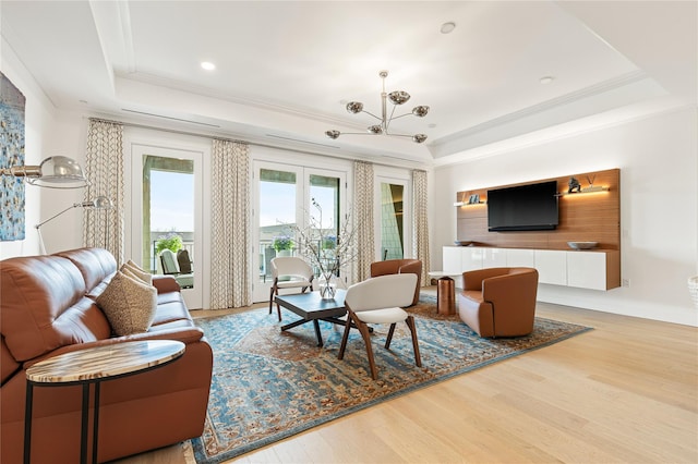 living room featuring crown molding, wood finished floors, an inviting chandelier, a tray ceiling, and recessed lighting