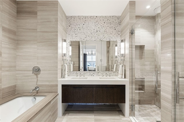 ensuite bathroom featuring vanity, tile walls, and connected bathroom