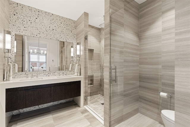 full bathroom with double vanity, toilet, a sink, and a stall shower