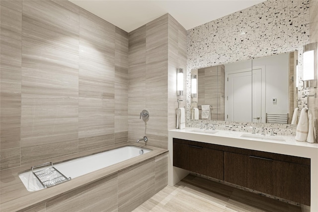 full bathroom featuring double vanity, a relaxing tiled tub, a tile shower, and a sink