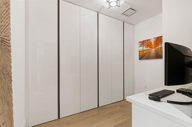 interior space with light wood finished floors and visible vents