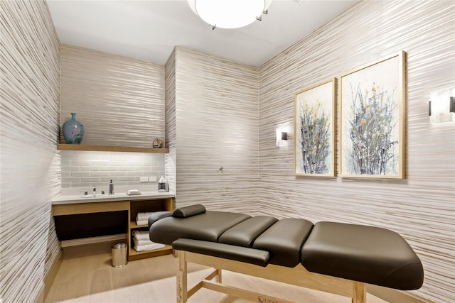 miscellaneous room featuring wood finished floors and tile walls