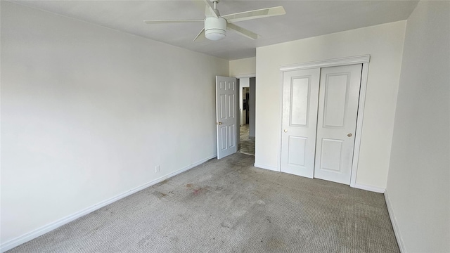unfurnished bedroom with carpet floors, baseboards, a ceiling fan, and a closet