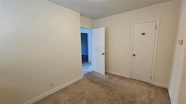 unfurnished room featuring carpet flooring and baseboards