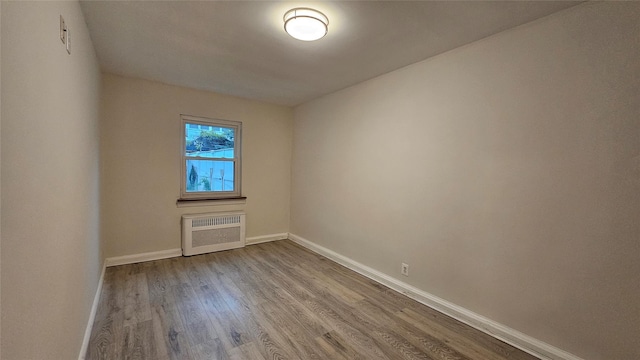 40-19 196th St, Flushing, NY 11358 - empty room with a wall unit AC, baseboards, and wood finished floors