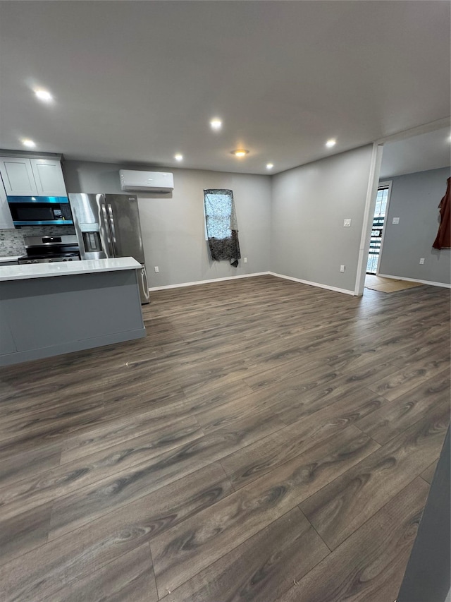 1161 E 88th St, Brooklyn, NY 11236 - living room featuring a wall unit AC, dark wood finished floors, recessed lighting, and baseboards