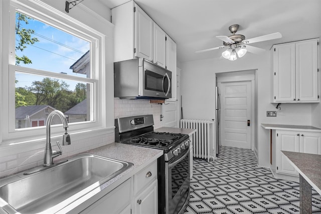 119 Western Hwy, West Nyack, NY 10994 - kitchen featuring a sink, white cabinetry, appliances with stainless steel finishes, and radiator heating unit