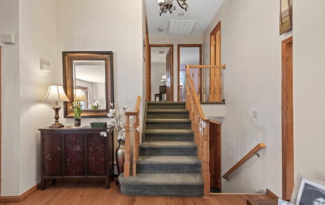 stairs featuring wood finished floors and visible vents