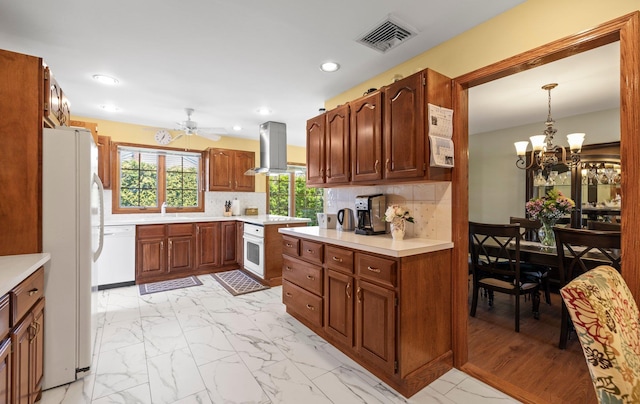kitchen featuring visible vents, white appliances, island range hood, light countertops, and ceiling fan with notable chandelier