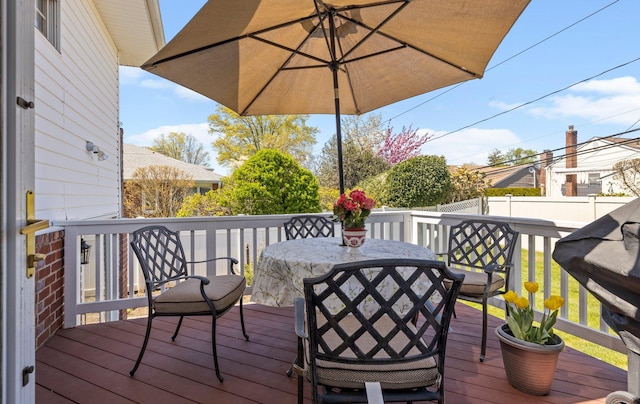 deck featuring outdoor dining area and a fenced backyard