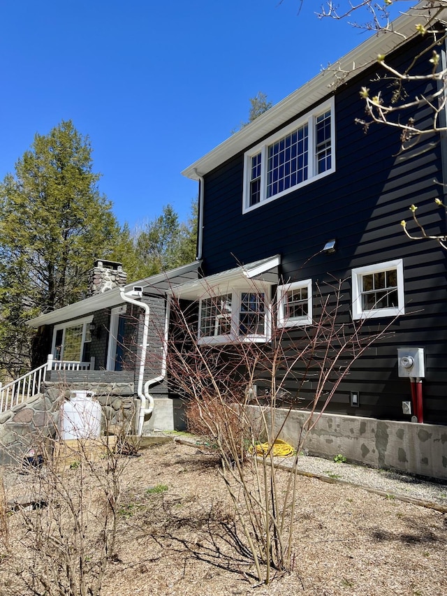 back of house featuring a chimney