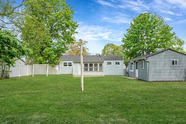 back of house featuring fence and a yard
