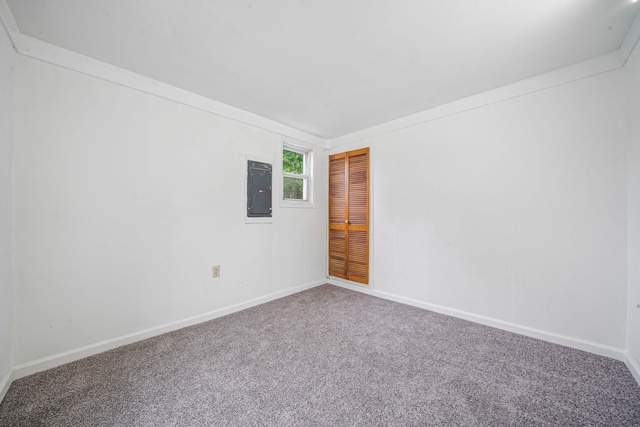carpeted spare room with baseboards and electric panel