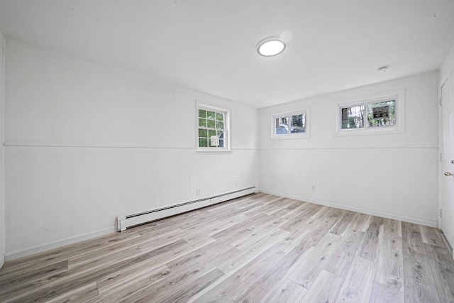 unfurnished room with baseboards, wood finished floors, and baseboard heating