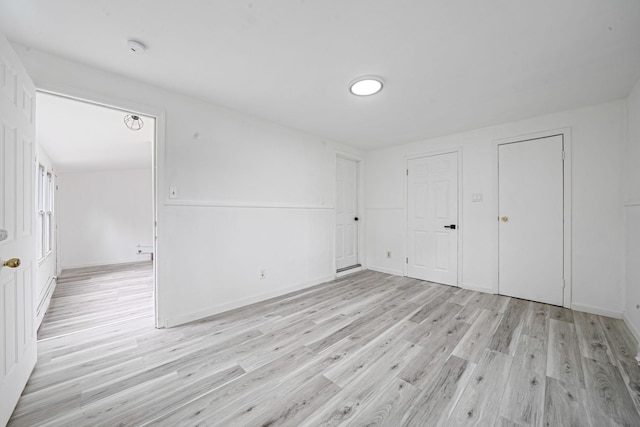 empty room with light wood-type flooring and baseboards