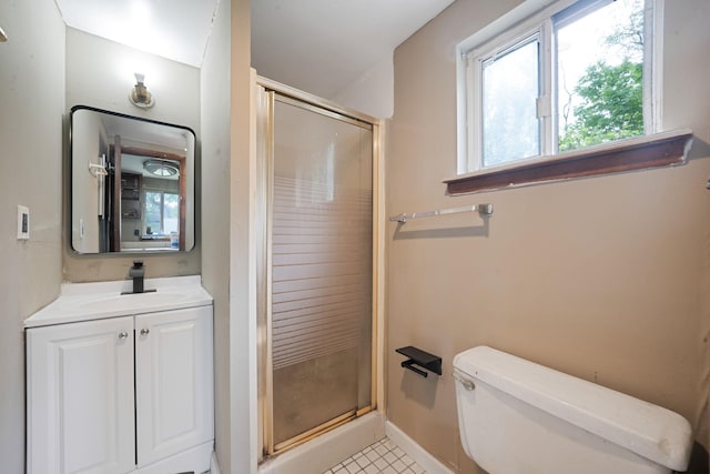 bathroom featuring vanity, toilet, baseboards, and a stall shower