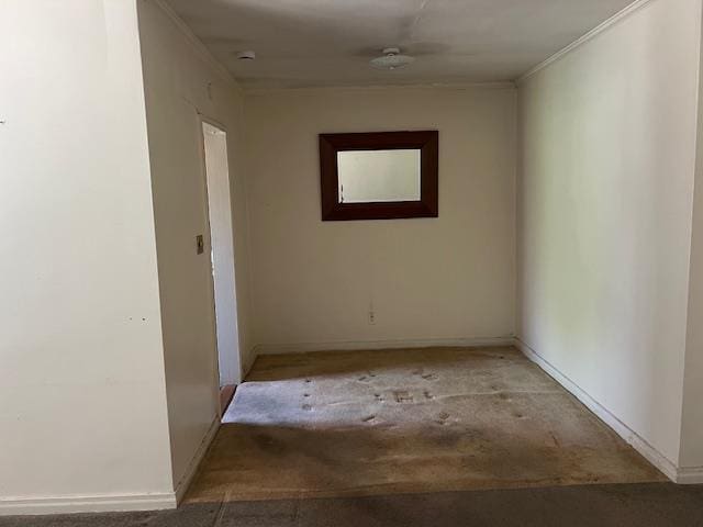 hall with baseboards, ornamental molding, and carpet