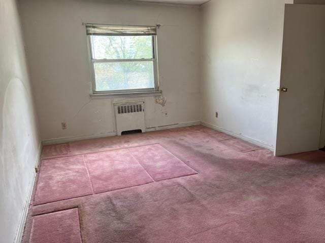 carpeted spare room featuring radiator heating unit