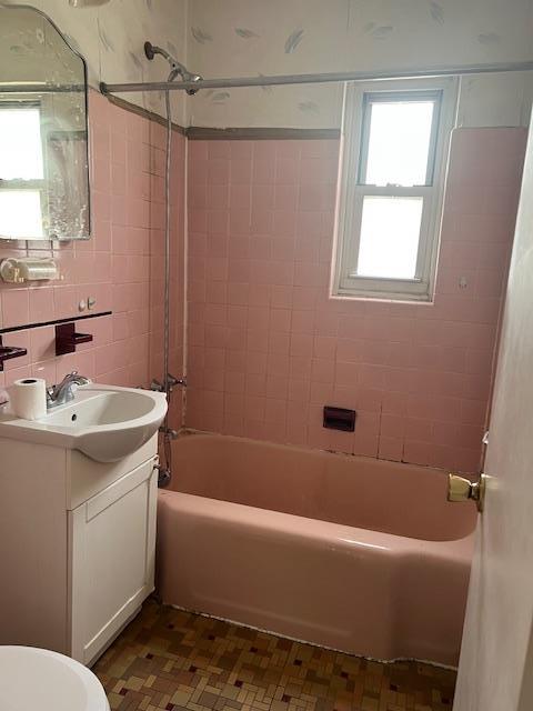 bathroom featuring shower / tub combination, vanity, toilet, tile patterned floors, and tile walls
