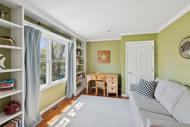 sitting room with baseboards, ornamental molding, wood finished floors, and visible vents