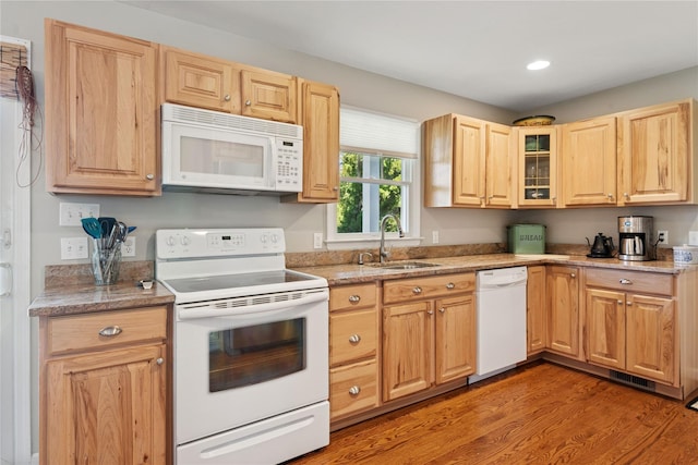 kitchen with light brown cabinetry, a sink, white appliances, recessed lighting, and light wood-type flooring