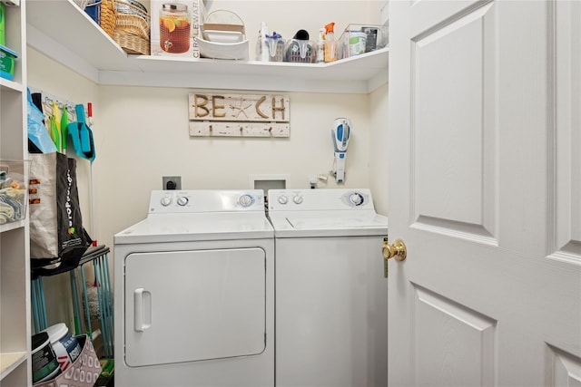 clothes washing area featuring separate washer and dryer and laundry area