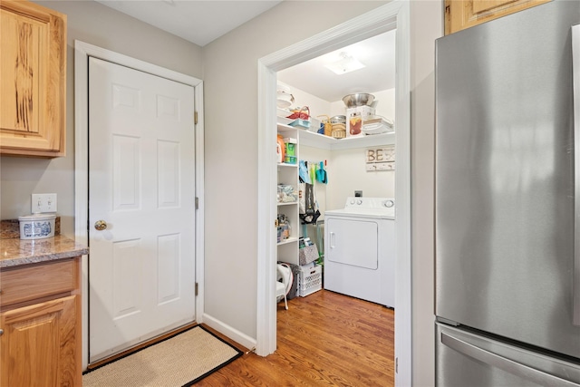 clothes washing area featuring laundry area, washer / dryer, and light wood-style floors