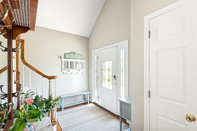 entryway featuring vaulted ceiling, stairs, and wood finished floors
