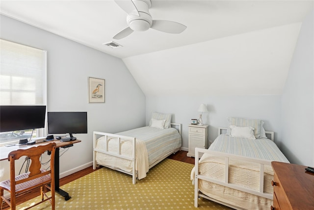 bedroom featuring ceiling fan, visible vents, wood finished floors, baseboards, and lofted ceiling
