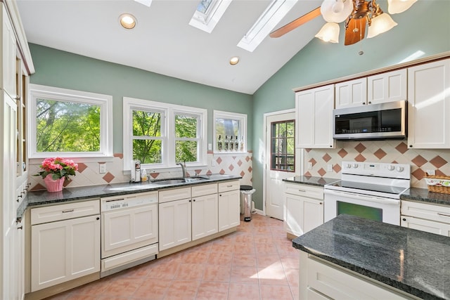 22 Washington Dr, Centerport, NY 11721 - kitchen with white appliances, a sink, a skylight, tasteful backsplash, and vaulted ceiling