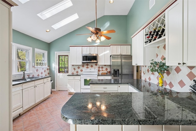 22 Washington Dr, Centerport, NY 11721 - kitchen with appliances with stainless steel finishes, a peninsula, backsplash, a sink, and a skylight