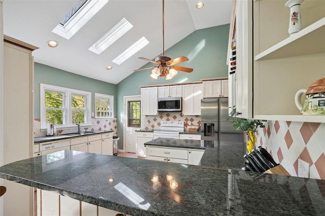 22 Washington Dr, Centerport, NY 11721 - kitchen featuring stainless steel appliances, a skylight, a sink, backsplash, and a peninsula