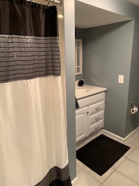 22 Washington Dr, Centerport, NY 11721 - bathroom with tile patterned floors, vanity, curtained shower, and baseboards
