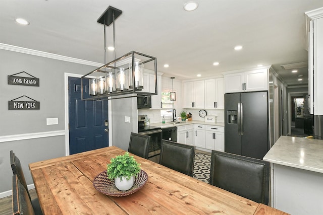 dining room featuring baseboards, ornamental molding, and recessed lighting
