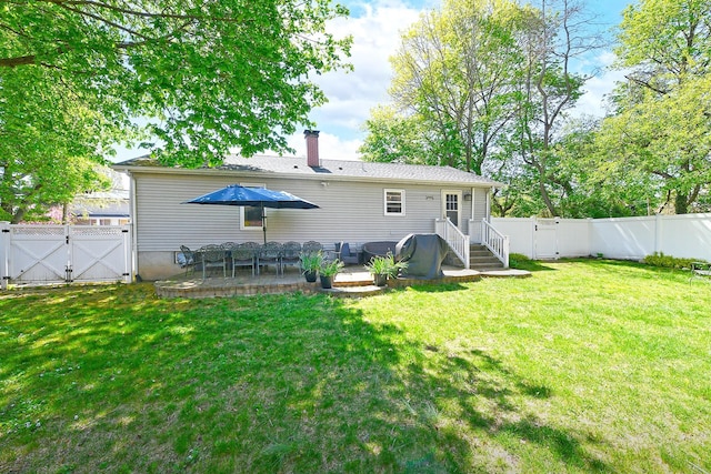 back of property featuring a lawn, a gate, a fenced backyard, and a chimney
