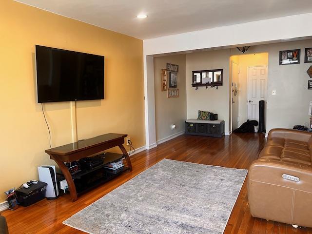 living area featuring baseboards, recessed lighting, and wood finished floors