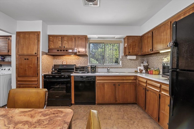 2 Yorktown Rd, Dix Hills, NY 11746 - kitchen with washer / dryer, light countertops, black appliances, and under cabinet range hood