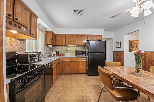 2 Yorktown Rd, Dix Hills, NY 11746 - kitchen with brown cabinets, light countertops, under cabinet range hood, visible vents, and black appliances