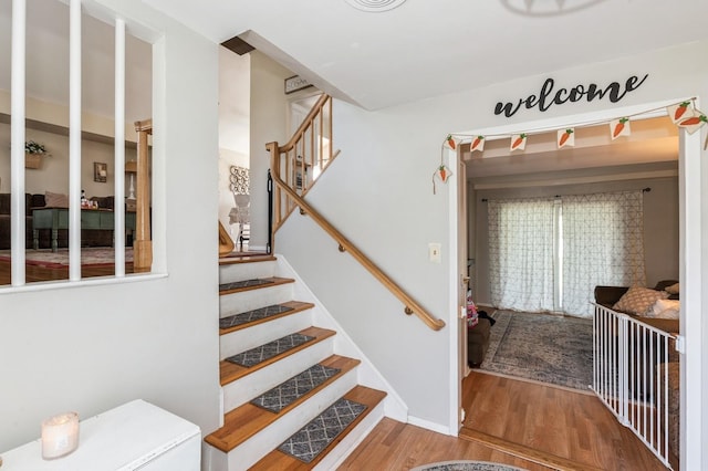 staircase featuring baseboards and wood finished floors