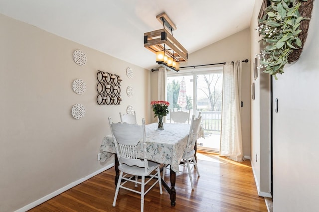 dining area featuring baseboards, wood finished floors, and a chandelier