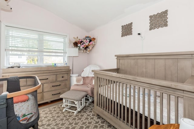 bedroom with a crib and vaulted ceiling