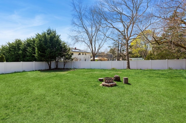 view of yard featuring a fenced backyard and a fire pit