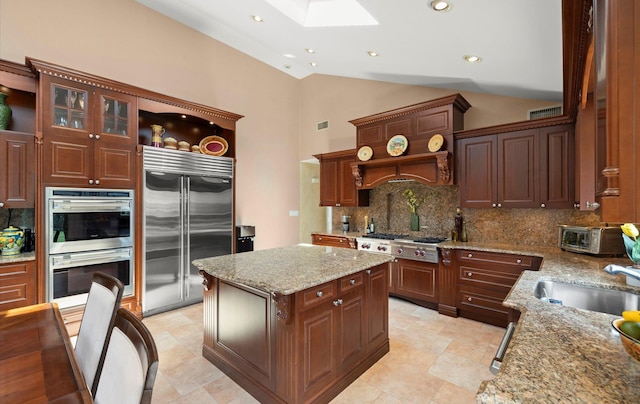 kitchen featuring open shelves, appliances with stainless steel finishes, a sink, tasteful backsplash, and a skylight