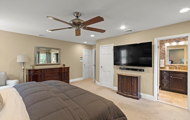 bedroom featuring visible vents, a sink, and light colored carpet