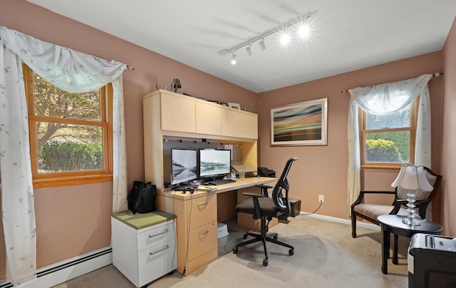 office space with baseboards, a baseboard radiator, light carpet, and rail lighting