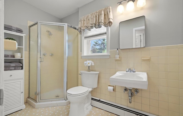 bathroom with a sink, tile patterned floors, a shower stall, and a baseboard heating unit