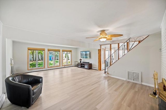 living area featuring visible vents, stairs, wood finished floors, baseboards, and a ceiling fan