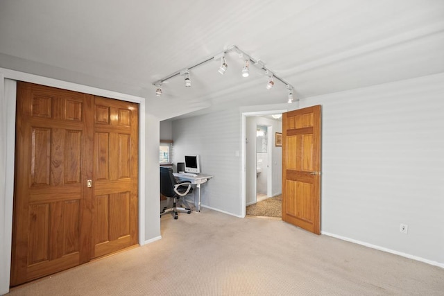 office area with baseboards, rail lighting, and light colored carpet
