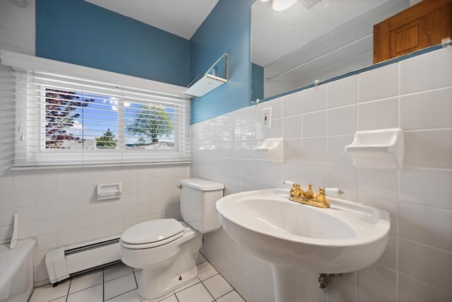 bathroom with a sink, tile patterned flooring, toilet, tile walls, and a baseboard radiator