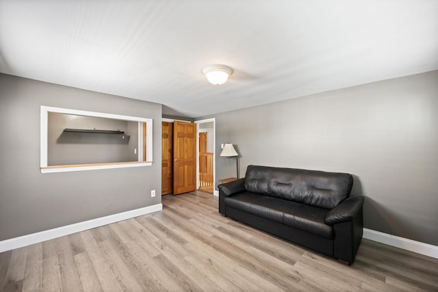 living area with baseboards and wood finished floors